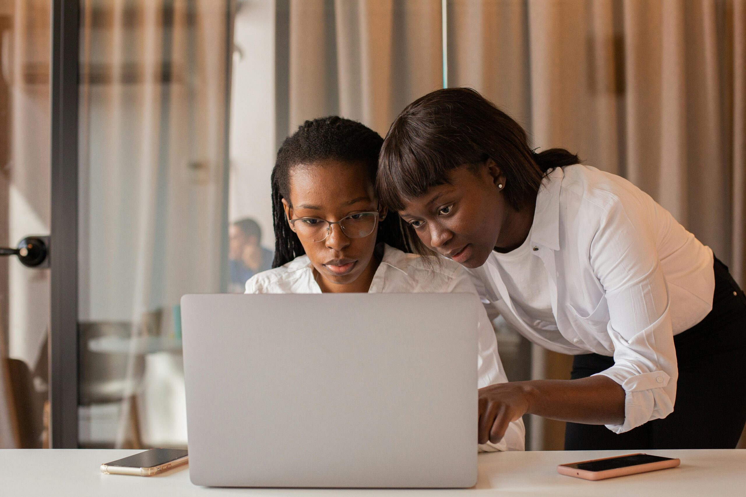 two people reviewing a laptop screen together