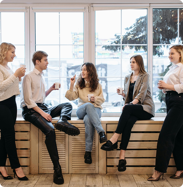 Group of young professionals sitting and standing while chatting together